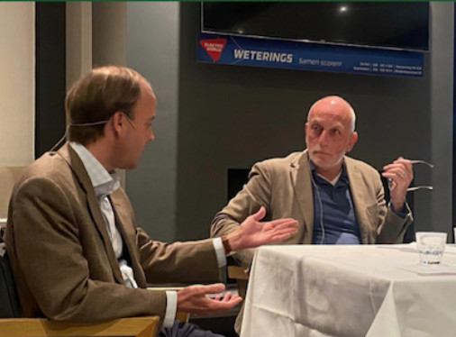 Peter de Bruin in interview aan tafel, warm avondlicht